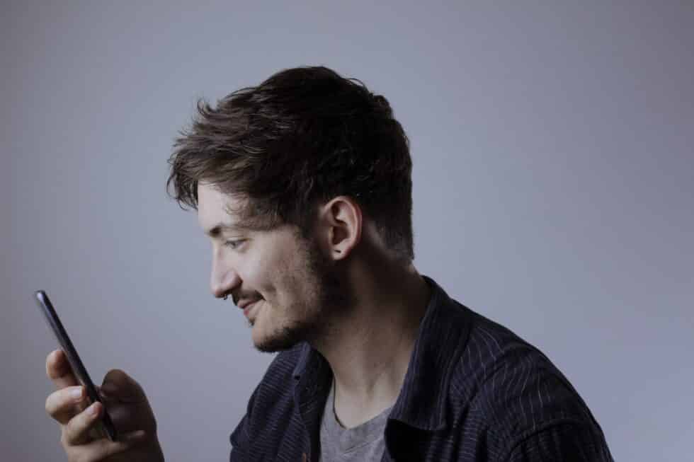 the modern gentleman holding phone tech