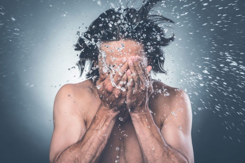 Man-washing-face-with-water-splashing