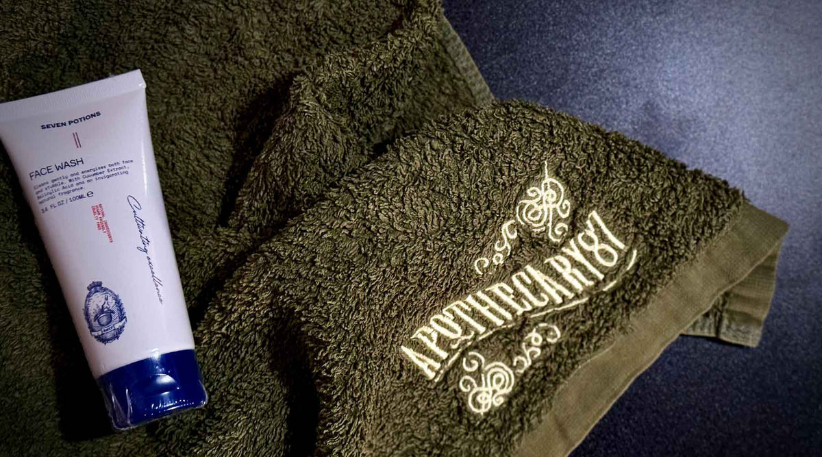 Men’s daily grooming ritual with face wash on a green towel against a black background